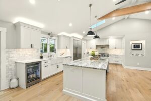 Bright modern kitchen with marble island and white cabinetry.