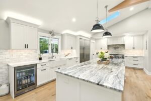 Bright modern kitchen with white cabinets and marble island.