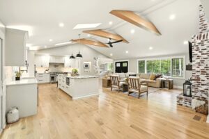 Bright, open-concept kitchen and living area with wooden accents and large windows.