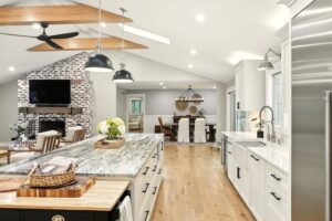 Modern kitchen with island, wooden floors, and elegant lighting.