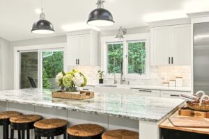 Bright modern kitchen with white cabinetry and marble countertops.