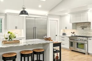 Modern kitchen with marble island and stainless steel appliances.