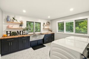 Bright modern kitchen with black cabinets and large windows.