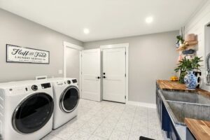 Modern laundry room with washer, dryer, and storage.