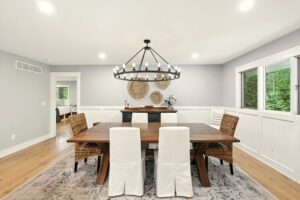 Modern dining room with a wooden table and white slipcovered chairs.