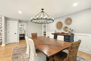 Elegant dining room with a large wooden table and chandelier.