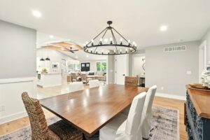 Spacious dining area with a large wooden table and chandelier.