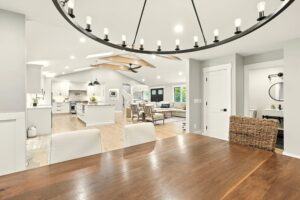 Bright, modern open-concept kitchen and living area with wooden dining table.