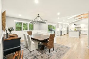 Bright, modern dining area with a large wooden table and mixed chairs.