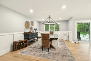 Modern dining room with a large wooden table and woven chairs.