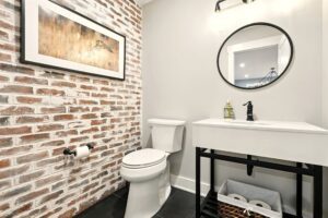 Modern bathroom with exposed brick and minimalist fixtures.