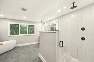 Modern bathroom with glass shower and large window.