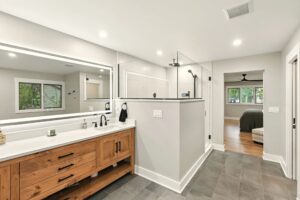 Modern bathroom with wooden vanity and walk-in shower.