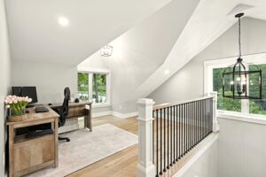 Bright modern home office with large windows and staircase.