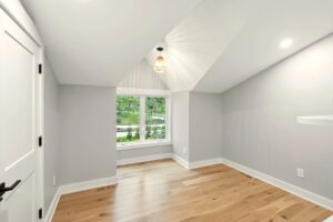 Bright empty room with hardwood floors and window.
