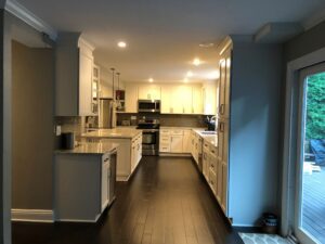 Modern kitchen with dark hardwood floors and white cabinetry.