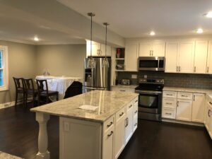 Modern kitchen with white cabinets and granite island.