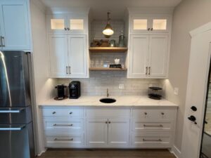 Bright kitchen with white cabinets, black sink, and modern appliances.