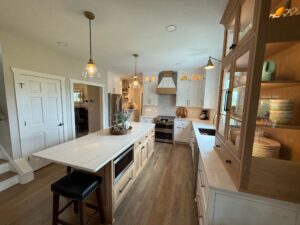 Modern kitchen with island, pendant lights, and wooden flooring.