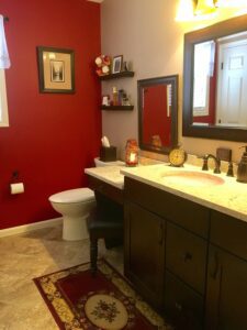Cozy bathroom with red walls and dark cabinetry.