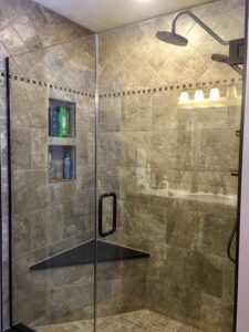 Modern glass shower with built-in shelves and bench.