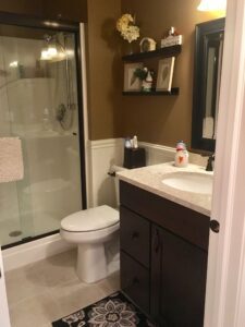 A clean, modern bathroom with glass shower, toilet, and vanity.