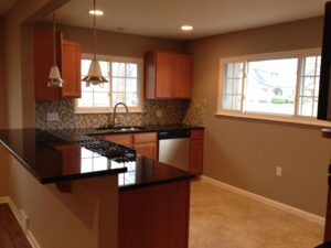 Modern kitchen with wood cabinets and granite countertops.