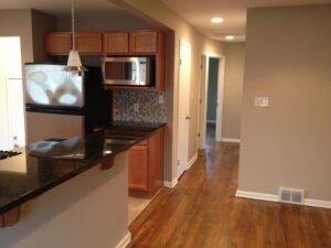 Modern kitchen with wooden floors and granite countertops.