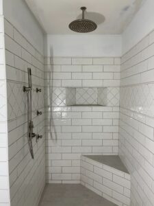 Modern shower with white subway tiles and bench seating.