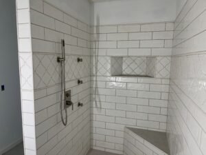 Modern tiled shower with built-in bench and niche.