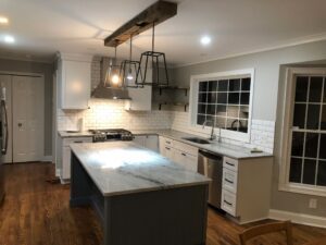 Modern kitchen with island, pendant lights, and white cabinetry.