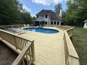 Skilled deck builders measuring wood for a large backyard project.