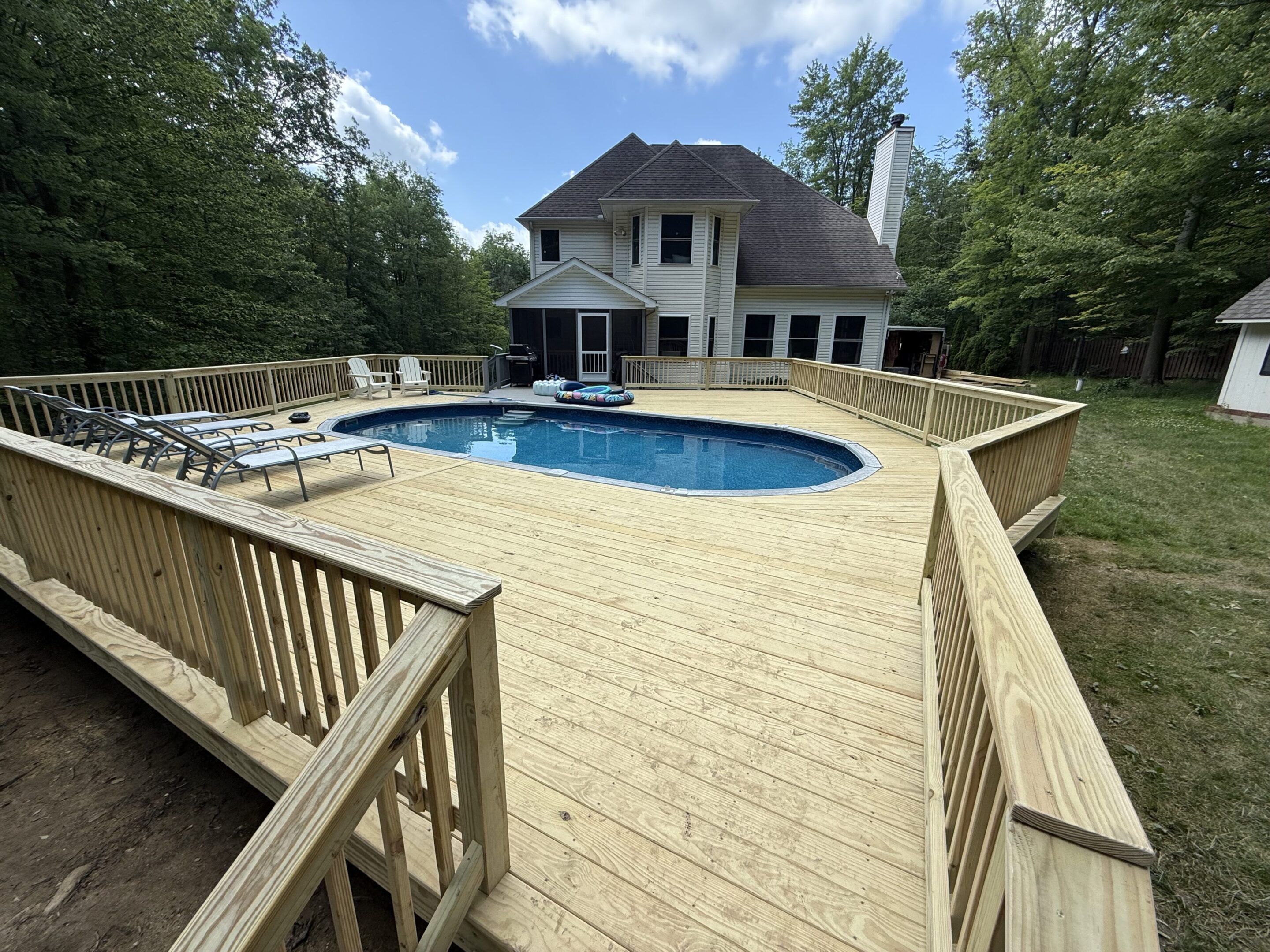 Skilled deck builders measuring wood for a large backyard project.