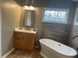 Modern bathroom with freestanding tub and wooden vanity.