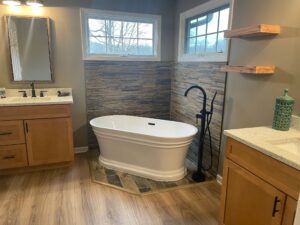 Modern bathroom with a white freestanding bathtub by corner windows.
