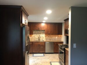 Modern kitchen with dark wood cabinets and stainless steel appliances.