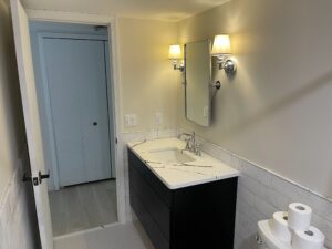 Modern bathroom with a black vanity and wall-mounted lamps.