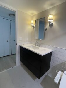 Modern bathroom with black vanity and dual wall sconces.
