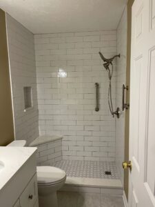 Modern bathroom with glass shower and white subway tiles.