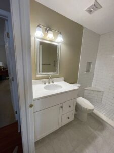 Modern bathroom with white vanity and toilet.