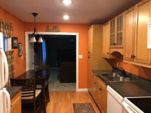 Cozy kitchen and dining area with warm lighting and orange walls.