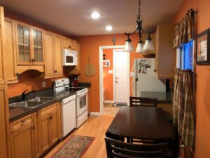 Cozy kitchen with wooden cabinets and orange walls.