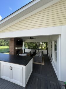 Modern outdoor kitchen and seating area under a covered patio.
