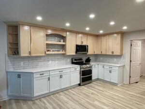 Modern kitchen with light wood cabinets and stainless steel appliances.