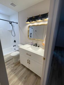 Modern bathroom with white vanity and black fixtures.