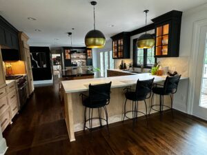 Modern kitchen with black cabinets and a large island.