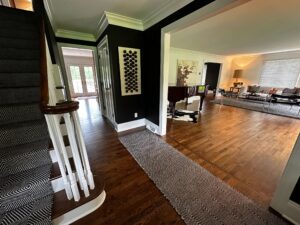A cozy home interior with a staircase, dark wall, and open living area.
