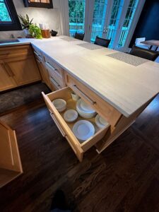 Open kitchen drawer with neatly organized dishes and bowls.