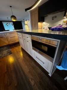 Modern kitchen with built-in microwave and wooden cabinets.