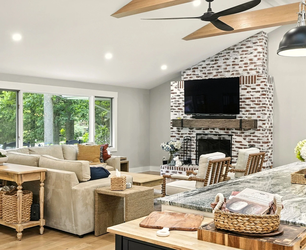 Cozy living room with stone fireplace and large windows.
